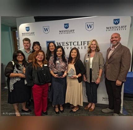 Group of people holding awards in front of Westcliff University banner